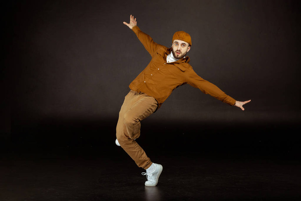 Young and handsome man in beige clothes standing in dance pose - Fotografie, Obrázek