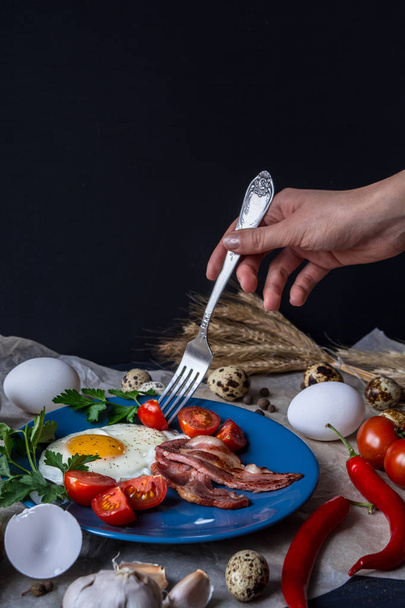 English breakfast composition with hand holding fork - Foto, afbeelding