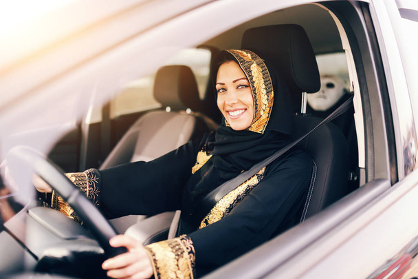 Hermosa mujer musulmana con sonrisa dentada coche de conducción
. - Foto, Imagen