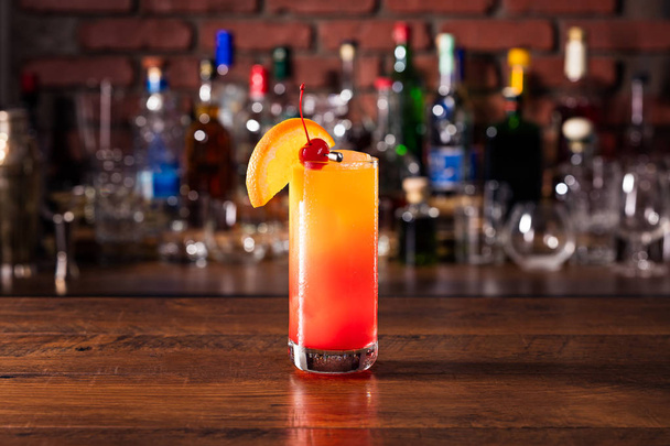Refreshing Tequila Sunrise Cocktail on a Bar - Fotó, kép