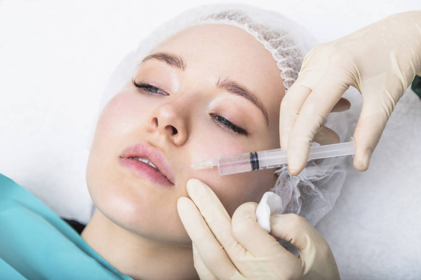 Cosmetic injection to womans lips in salon - Fotó, kép