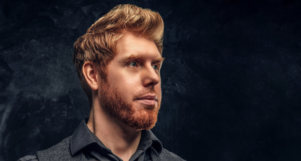 Elegáns haj és szakáll Studio egy sötét texturált falhoz szép vörös hajú férfi képmása - Fotó, kép