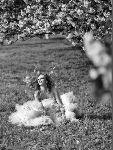 Sensual woman on grass with bloom - Fotoğraf, Görsel