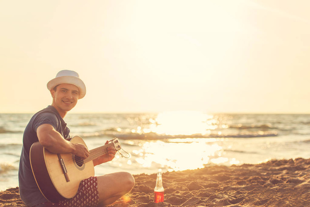 Νεαρός παίζουν κιθάρα στην παραλία - Φωτογραφία, εικόνα