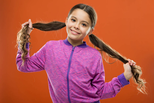 Small child long hair. Charming beauty. Girl active kid with long gorgeous hair. Strong and healthy hair concept. How to treat curly hair. Nice and tidy hairstyle. Easy tips making hairstyle for kids - Zdjęcie, obraz