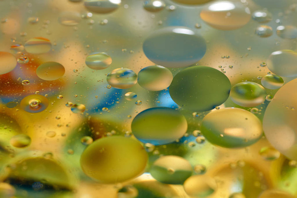 плавающие в воде абстрактные красочные, желтые капли масла
 - Фото, изображение
