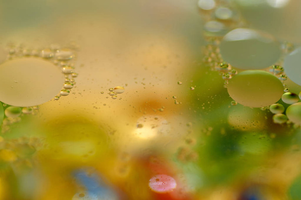 плавающие в воде абстрактные красочные, желтые капли масла
 - Фото, изображение