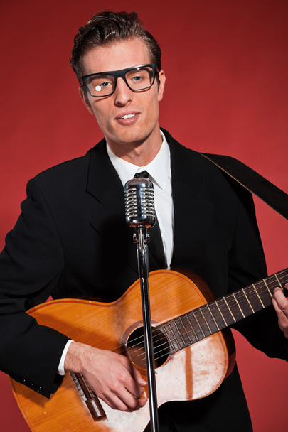 Retro fifties singer with glasses playing acoustic guitar. Studi - Photo, Image