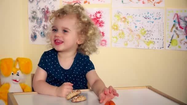 A criança pequena escolhe bolos de mel não cenouras e come-os
 - Filmagem, Vídeo