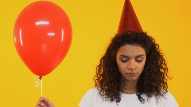 Upset teenage girl holding balloon, feeling lonely on birthday party, no friends - Кадры, видео