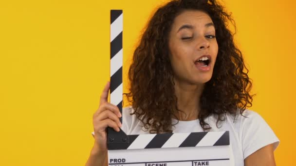 Woman winking and using clapper board, shooting positive film, movie production - Imágenes, Vídeo