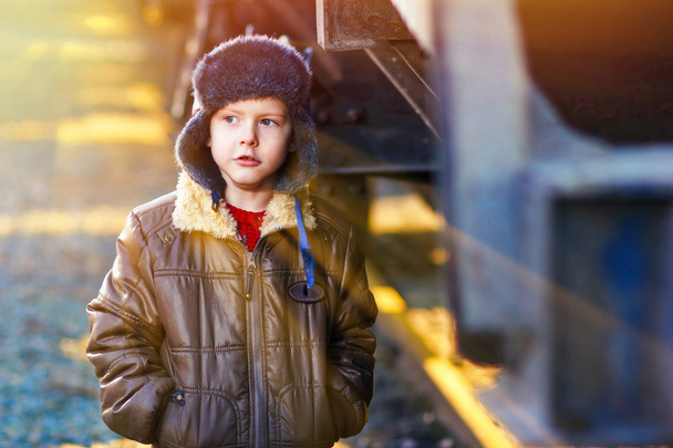 Солнечный свет Мальчик бездомный бродяга на улице замерзает рядом с железной дорогой ок
 - Фото, изображение