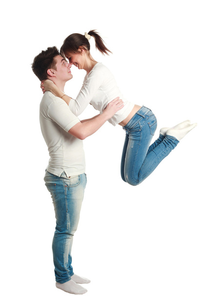 Young couple, guy with jumping up girl, studio, isolated - Foto, imagen