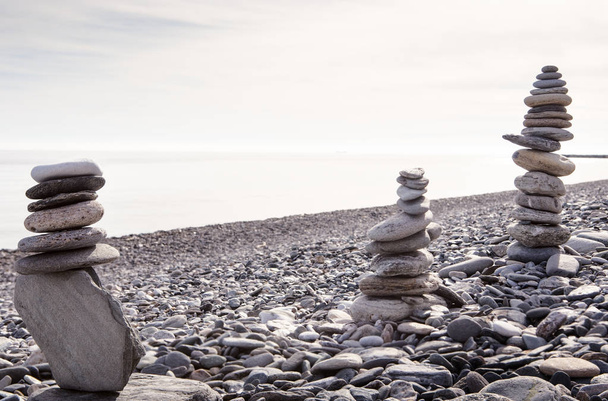 Kiven tasapainottaminen tai kiven tasapainottaminen, luonnollisesti tasapainotettu rannalla meren takana
 - Valokuva, kuva