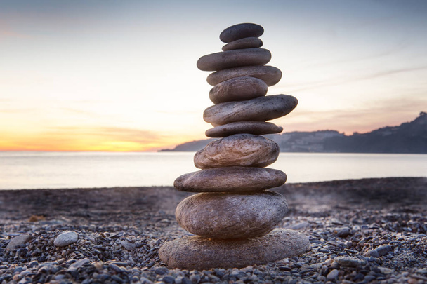 Rock in evenwicht brengen of stenen balancin, natuurlijk evenwicht op een strand met de zee achter - Foto, afbeelding