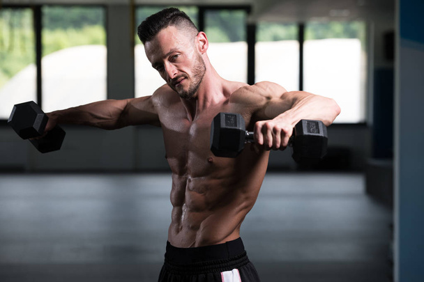 Athlete Working Out Shoulders In A Gym - Dumbbell Concentration Curls - Fotografie, Obrázek