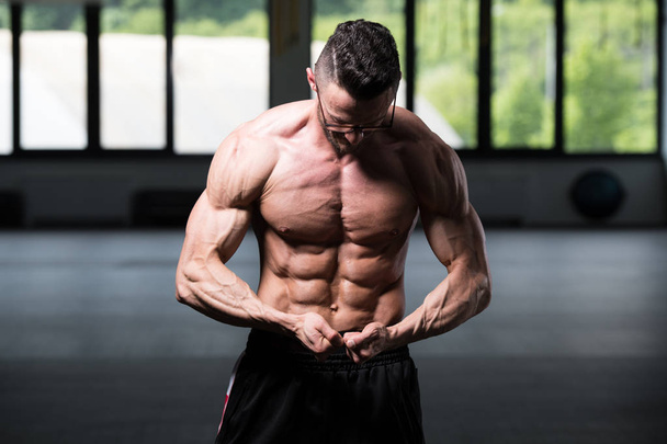 Portrait Of A Young Physically Fit Nerd Man Showing His Well Trained Body - Muscular Athletic Bodybuilder Fitness Model Posing After Exercises - Zdjęcie, obraz