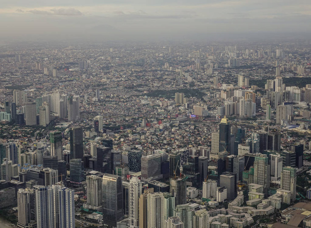  Luftaufnahme der Stadt Manila mit Wolkenkratzern und Gebäuden. Manila ist die am dichtesten bevölkerte Stadt der Welt. - Foto, Bild