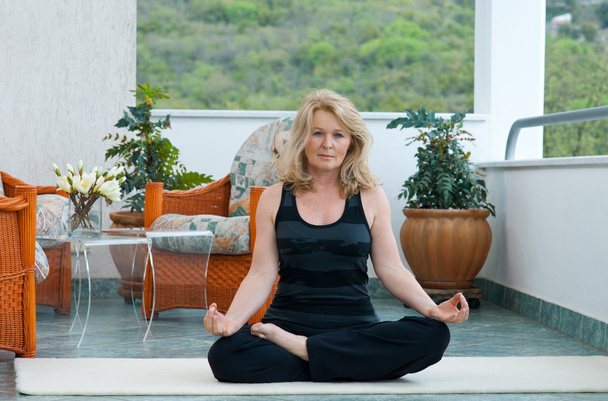 reife Frau in Yogaposition - Foto, Bild