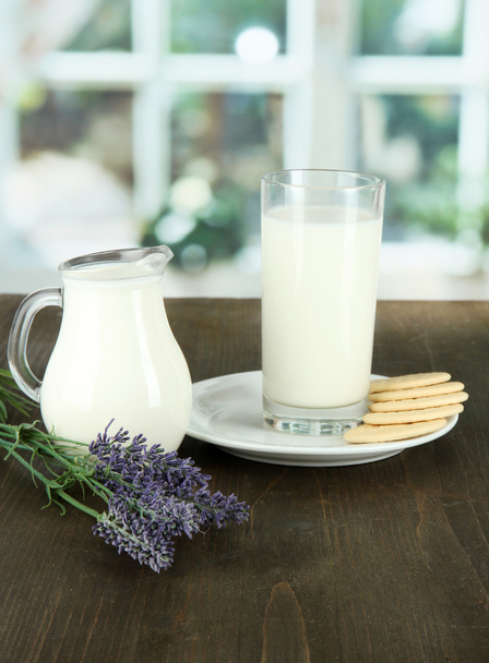 Glas Milch, eine Kanne und Kekse auf einem Raumhintergrund - Foto, Bild