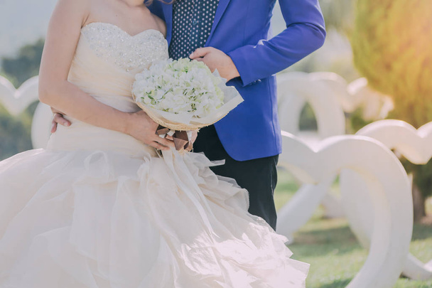 Gli sposi si uniscono le mani e tengono un bellissimo bouquet il giorno del matrimonio
. - Foto, immagini