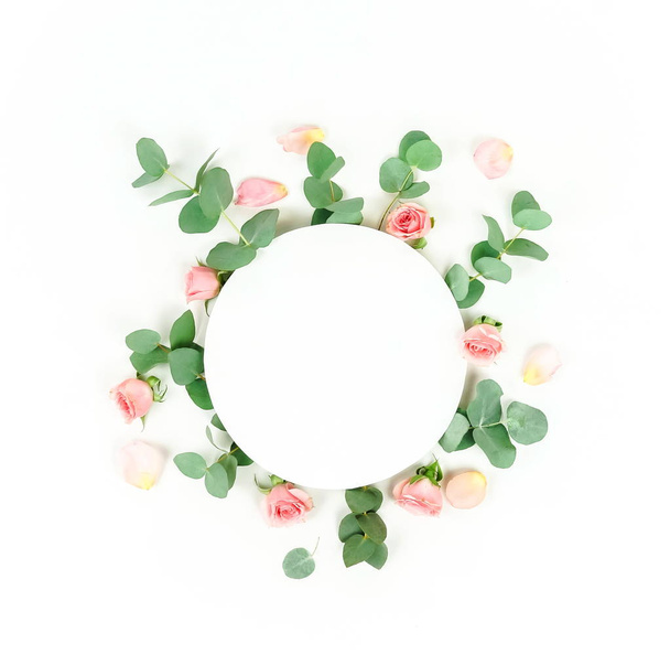 top view of roses and green leaves arranged on white backdrop - Фото, зображення