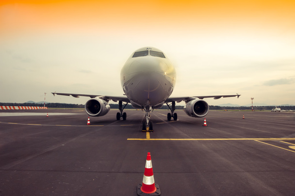 εμπορικό αεροπλάνο στάθμευσης στο αεροδρόμιο, με κώνο της κυκλοφορίας σε - Φωτογραφία, εικόνα