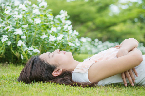 asiatique femme couché et dormir sur herbe champ après elle fatigué dans l 'après-midi
 - Photo, image