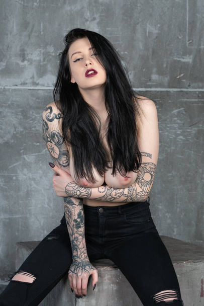 joven hermosa chica posando desnuda en el estudio, de pie en jeans negros
 - Foto, imagen