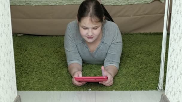 девушка играет на планшете в комнате, веб-серфинг, отдых
 - Кадры, видео