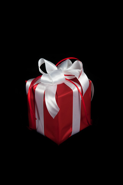 Red gift box on black - Фото, изображение