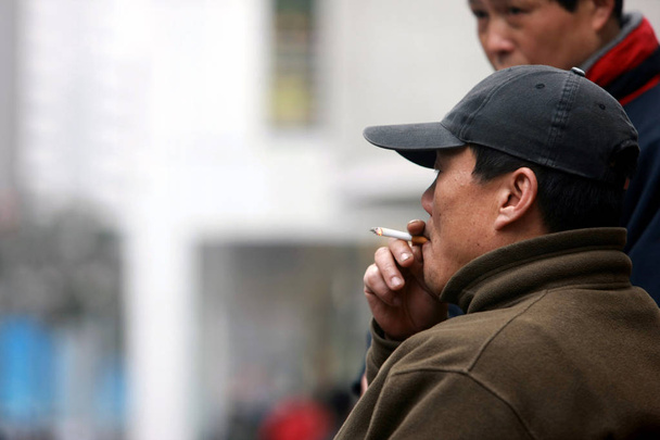 A Chinese man smokes in Shanghai, China, March 5, 2009 - Φωτογραφία, εικόνα