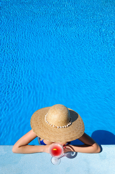 vrouw bij zwembad met kosmopolitische cocktail - Foto, afbeelding