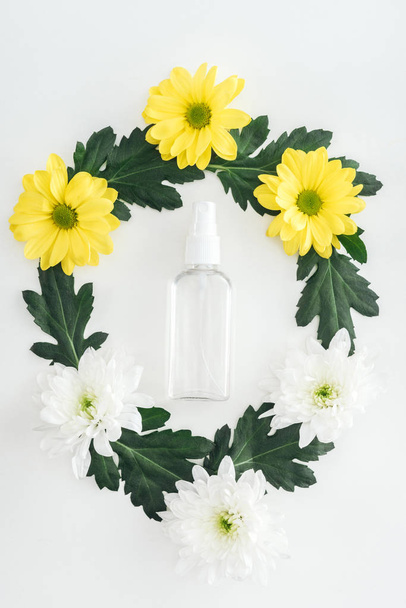 top view of empty spray bottle with white and yellow chrysanthemums on white background - Photo, Image