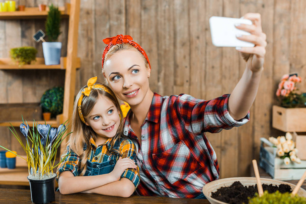 selective focus of beautiful mother taking selfie with cute daughter - Photo, Image