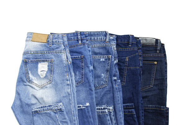 Набор различных синих джинсов изолирован на белом фоне сверху вид плоский. Деталь хороших синих джинсов. Джинсы текстура или джинсовый фон. Модная одежда. Красота и мода, одежда
 - Фото, изображение