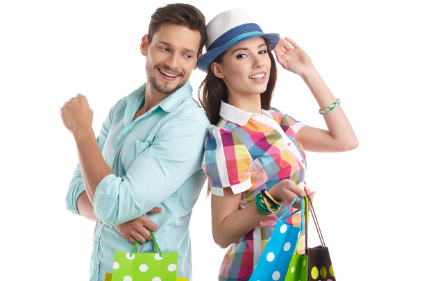 Attractive young couple with shopping bags on white background - Fotó, kép