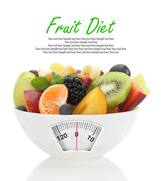 Pasto dietetico. Insalata di frutta in una ciotola con bilancia di peso
 - Foto, immagini