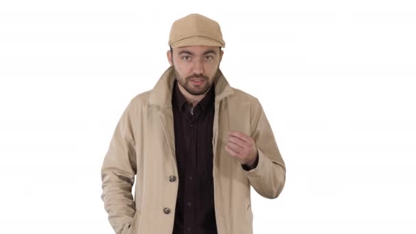 A positive bearded male dressed in a trench coat walking and talking on white background. - Filmati, video