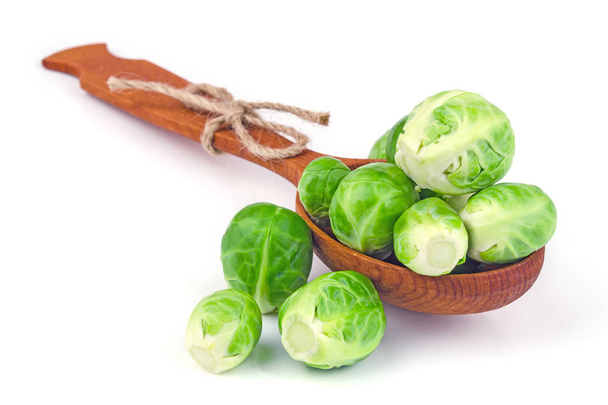 Brussels sprouts imposed on a wooden spoon on a white background - Photo, Image