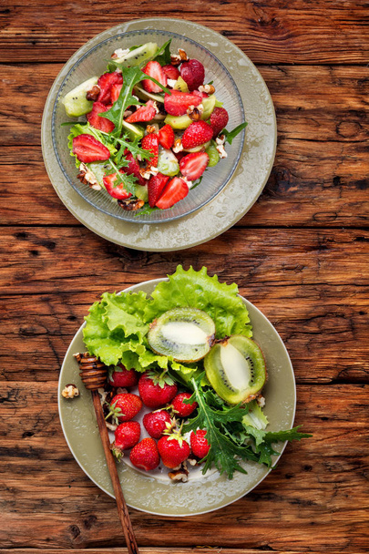 Salada com morango, rúcula e kiwi em mesa de madeira.Salada de dieta saudável
 - Foto, Imagem