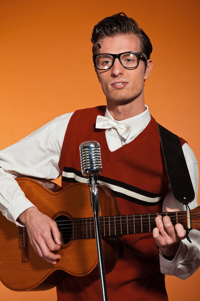 Musicista retrò anni Cinquanta con occhiali che suonano la chitarra acustica. Stu
 - Foto, immagini