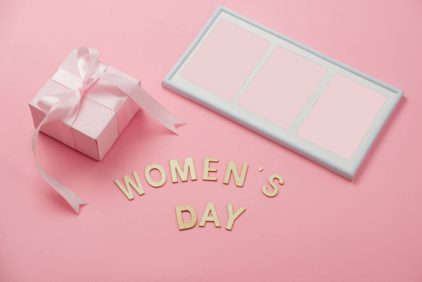 Vrouwen dag concept, dag van de gelukkige vrouw, internationale Vrouwendag. Dames dag tekst houten, roze geschenk met fotolijst op koraal achtergrond - Foto, afbeelding