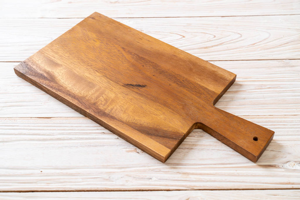 empty cutting wooden board with kitchen cloth on wood background - Foto, imagen
