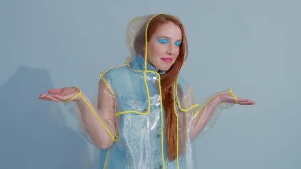 gember haar vrouw in transparante regenjas met popart lichte make-up dansen - Video