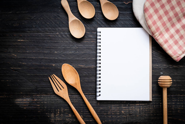 blank notebook for text note on wooden surface and wooden spoon and fork with copy sapce - Fotó, kép