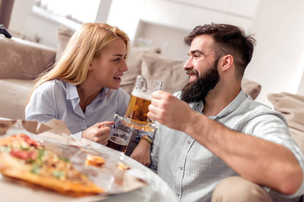 junges Paar isst Pizza und trinkt Bier. - Foto, Bild
