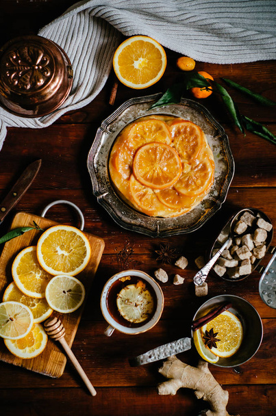 Sweet pie with orange caramelized slices on wooden background, top view - Foto, Imagem
