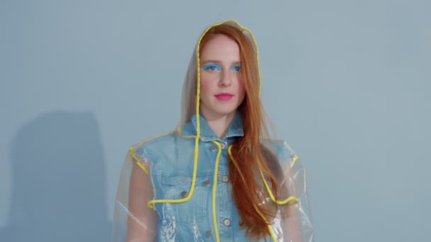 mujer de pelo jengibre en impermeable transparente con el arte pop brillante maquillaje baile
 - Metraje, vídeo