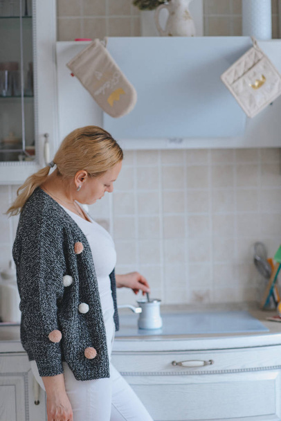 cheerful mid adult caucasian woman preparing coffee at kitchen - Фото, зображення